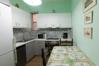 a kitchen with white cabinets and a table and a microwave at Athens center traditional & classic 2BR apartment in Mesochórion