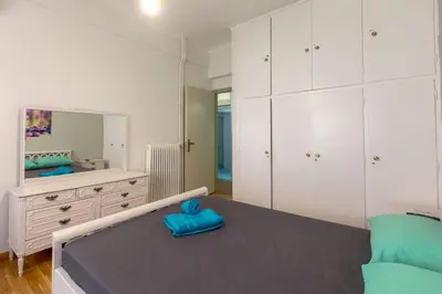a bedroom with a bed and a large mirror at Athens center traditional & classic 2BR apartment in Mesochórion