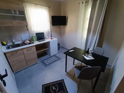 a small kitchen with a desk and a table with chairs at knezevic resorts 14 in Athens