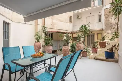 a patio with a table and chairs on a balcony at The Courtyard Oasis in Athens