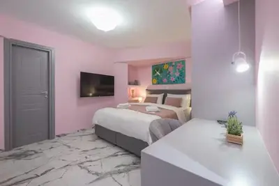 a hotel room with a bed and a television and a room at The Courtyard Oasis in Athens
