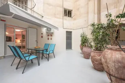 a patio with chairs and a table and some plants at The Courtyard Oasis in Athens