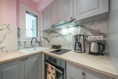 a kitchen with white cabinets and a counter top at The Courtyard Oasis in Athens