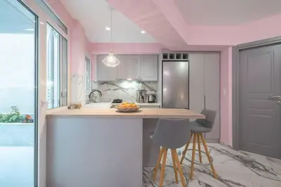 a kitchen with a island with two bar stools at The Courtyard Oasis in Athens