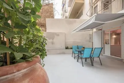 a patio with blue chairs and a table on a building at The Courtyard Oasis in Athens