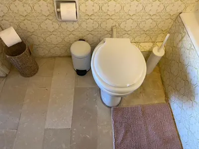 a bathroom with a toilet and a trash can at Sunset apartment Saronida by the sea with stunning view in Saronida