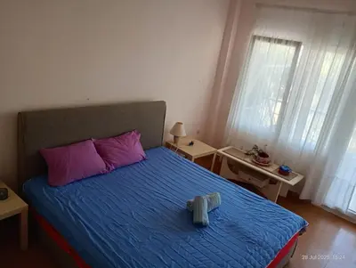 a bedroom with a bed with purple and pink pillows at Sunset apartment Saronida by the sea with stunning view in Saronida