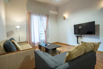 a living room with a couch and a flat screen tv at Athenian Getaway near Metro-Agios Nikolaos by ΜΡS in Athens
