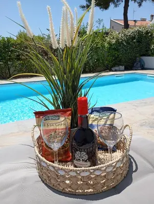 a basket of wine and glasses next to a pool at Anemelia & Helios Studio in Anavissos