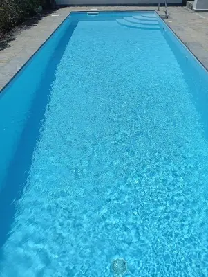 a large blue swimming pool with blue water at Anemelia & Helios Studio in Anavissos