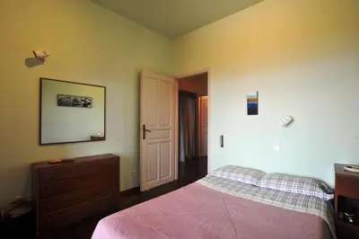 a bedroom with a bed and a dresser and a door at Villa Almy - shared pool with 1 house in Anavissos
