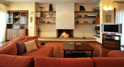 a living room with a couch and a fireplace at Villa Almy - shared pool with 1 house in Anavissos