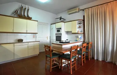 a kitchen with a table and chairs in a room at Villa Almy - shared pool with 1 house in Anavissos