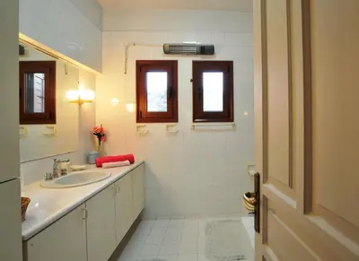 a white bathroom with a sink and a mirror at Villa Almy - shared pool with 1 house in Anavissos