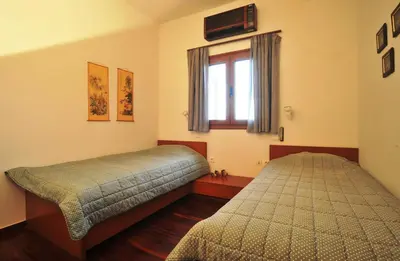 a bedroom with two beds and a window at Villa Almy - shared pool with 1 house in Anavissos
