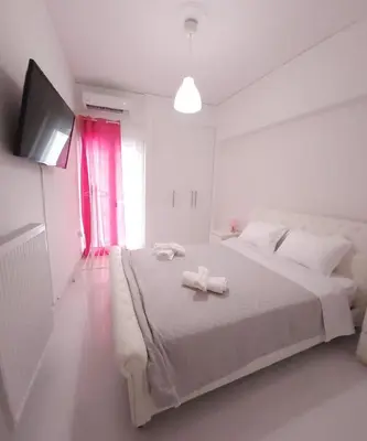 a white bedroom with a bed with two towels on it at Elegant-Quiet 2' Metro Center in Athens