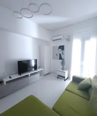 a living room with a green couch and a television at Elegant-Quiet 2' Metro Center in Athens