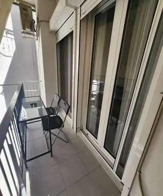 a balcony with a table and chairs on a building at Elegant-Quiet 2' Metro Center in Athens