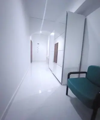 a hallway with a green chair in a white room at Elegant-Quiet 2' Metro Center in Athens