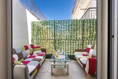 a balcony with couches and a table in a building at Komis House - Cozy Stay near Metro in Athens