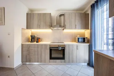 a kitchen with wooden cabinets and a microwave at Komis House - Cozy Stay near Metro in Athens