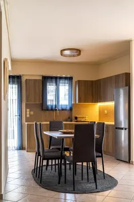 a kitchen with a table and chairs and a refrigerator at Komis House - Cozy Stay near Metro in Athens