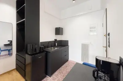 a black kitchen with a sink and a mirror at Athens Vibes City Studio in Athens
