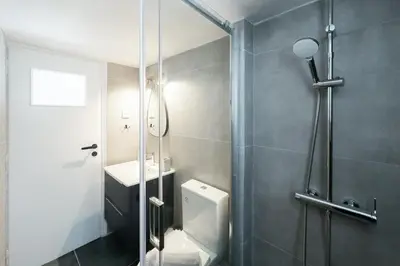 a bathroom with a shower with a toilet and a sink at Urban Apartment on Top with View in Athens