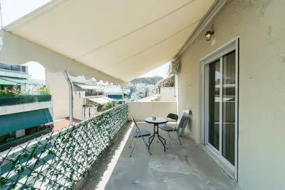 a balcony with a table and chairs on a building at Urban Apartment on Top with View in Athens