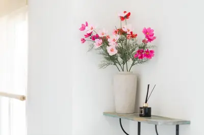 a vase of flowers on a table next to a window at Urban Apartment on Top with View in Athens