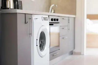 a white washing machine in a kitchen with a sink at Urban Apartment on Top with View in Athens