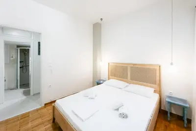 a bedroom with a white bed and a bathroom at My Athens Home near Metro Station in Athens