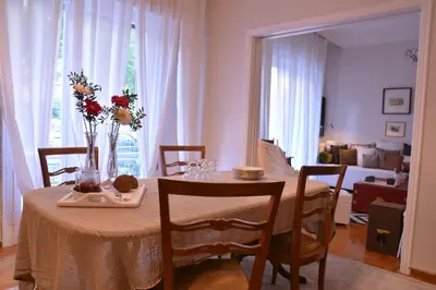 a dining room table with a vase of flowers on it at Detached House 4km away from Acropolis & Riviera in Athens