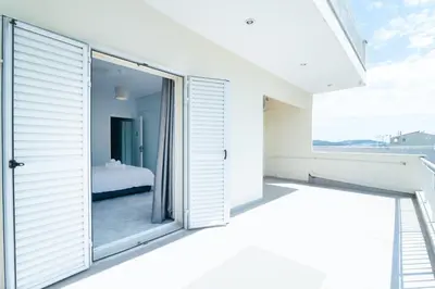 an open sliding glass door to a bedroom with a bed at Roof Top Apartment By Athens Airport in Spáta
