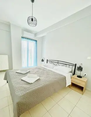 a bedroom with a large bed with two trays on it at Roof Top Apartment By Athens Airport in Spáta