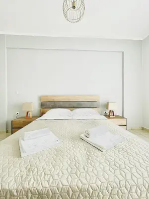 a bedroom with a large bed with two towels on it at Roof Top Apartment By Athens Airport in Spáta