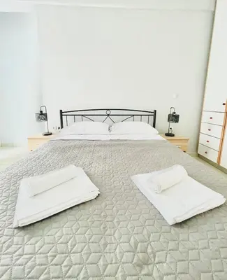 a bedroom with a bed with two towels on it at Roof Top Apartment By Athens Airport in Spáta