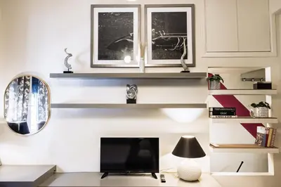 a room with shelves and a tv and a mirror at Regal Studio Athens in Athens