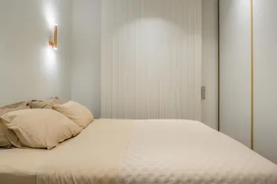 a bed with white sheets and pillows in a room at The Tone - Kolonaki in Athens