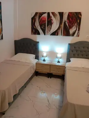 two beds in a room with two lamps on tables at PARTHENON In HORIZON in Athens