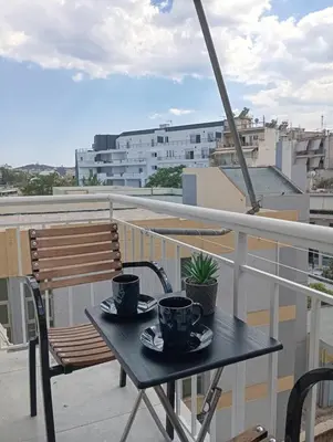 a table on a balcony with two coffee cups on it at PARTHENON In HORIZON in Athens