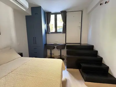 a bedroom with a bed and a staircase with a mirror at Relax adobe in central Athens in Athens