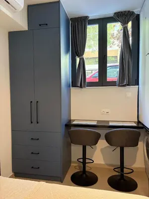 a desk and two chairs in a room with a window at Relax adobe in central Athens in Athens