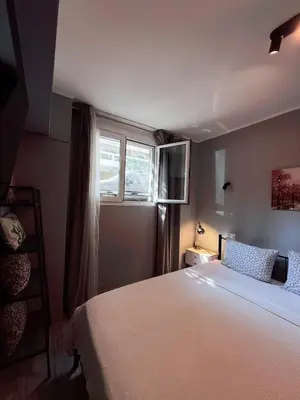 a bedroom with a large bed and a window at The Kallithea Spot Studio 1 in Athens