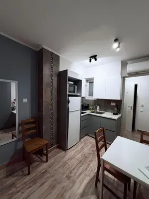 a kitchen with a table and chairs and a refrigerator at The Kallithea Spot Studio 1 in Athens