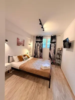 a bedroom with a bed and a tv in it at The Kallithea Spot Studio 2 in Athens