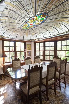 a dining room with a table and a stained glass ceiling at Villa Lagonisi, magnificent Villa in the Athenian Riviera in Áyios Nikólaos