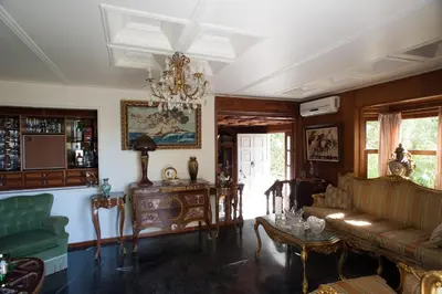 a living room with a couch and a chandelier at Villa Lagonisi, magnificent Villa in the Athenian Riviera in Áyios Nikólaos