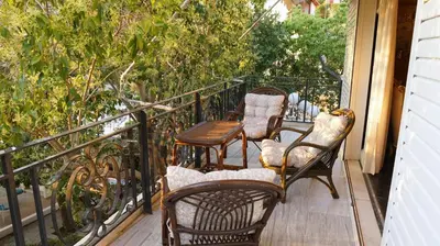 three chairs and a table on a balcony at Villa Lagonisi, magnificent Villa in the Athenian Riviera in Áyios Nikólaos