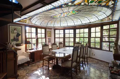 a dining room with a table and a stained glass ceiling at Villa Lagonisi, magnificent Villa in the Athenian Riviera in Áyios Nikólaos